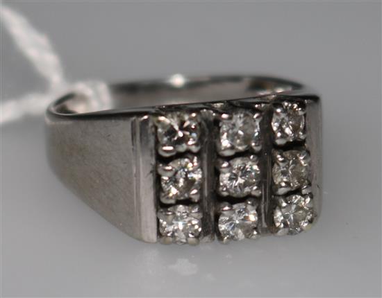 A white metal (tested as 18ct gold) ring set with nine diamonds, size G.